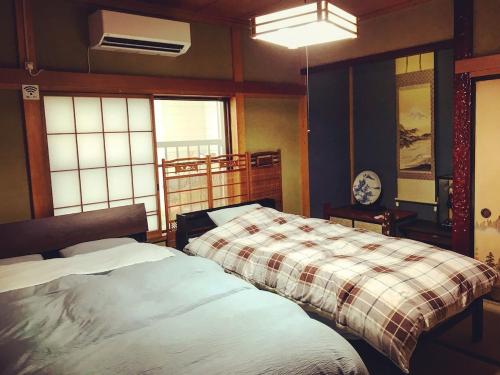una camera da letto con due letti in una stanza con finestre di Right nearby world heritage! 2BR Nikko Stay house a Nikko