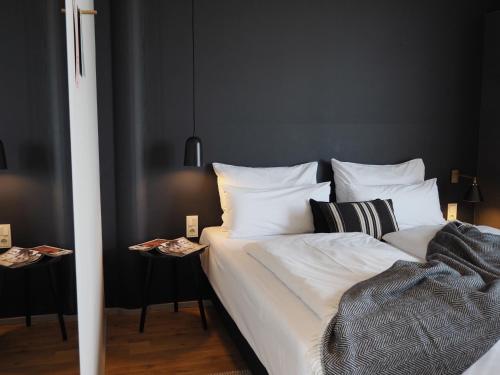 a bedroom with a bed with white sheets and pillows at Bold Hotel München Giesing in Munich