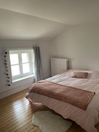 une chambre avec un grand lit et une fenêtre dans l'établissement Pretty house with garden near Reims Champagne, à Cormontreuil