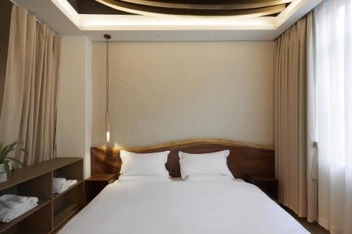 a bed with two white pillows in a room at 汕头寂居 Shantou Ancient City Design Hotel in Shantou
