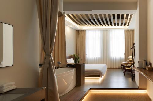 a hotel room with a bed and a bath tub at 汕头寂居 Shantou Ancient City Design Hotel in Shantou