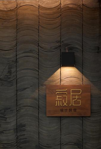 a light in a room with a wooden wall at 汕头寂居 Shantou Ancient City Design Hotel in Shantou