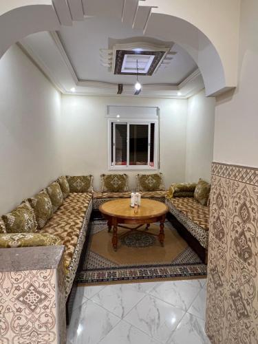 ein Wohnzimmer mit Couch und Tisch in der Unterkunft إقامة بدر in Asilah
