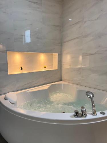 a bath tub with a faucet in a bathroom at Khunnapat Pool Villa Pranburi in Ban Huai Thalaeng Phan