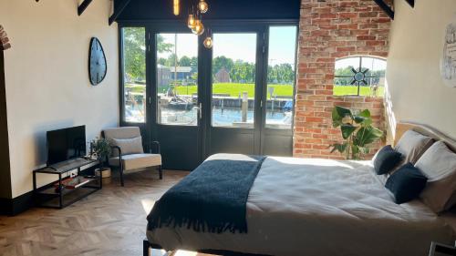 a bedroom with a bed and a brick wall at B & B Havenzicht Elburg in Elburg