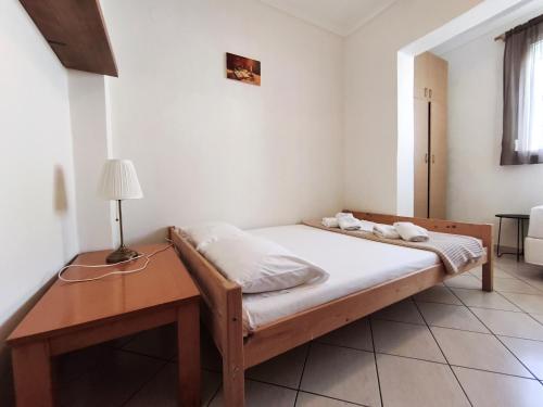 a bedroom with a bed and a table with a lamp at Casa Mameli Αpartments in Kallithea Halkidikis