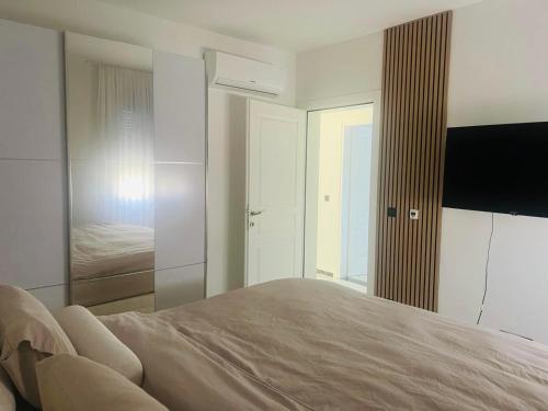 Un dormitorio con una cama grande y un espejo. en Villa Nova Bar, en Bar