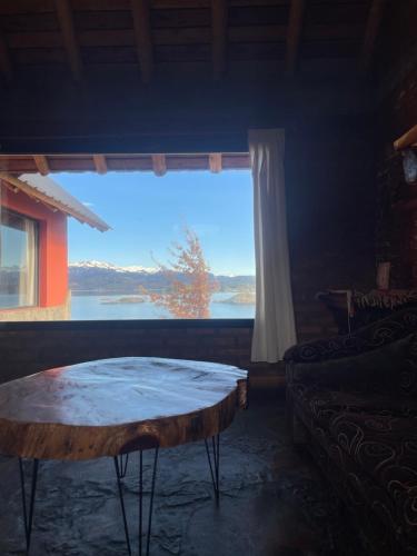 a room with a table and a large window at Complejo Don Cirilo in Villa Pehuenia