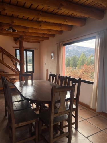a dining room with a table and chairs and a window at Complejo Don Cirilo in Villa Pehuenia