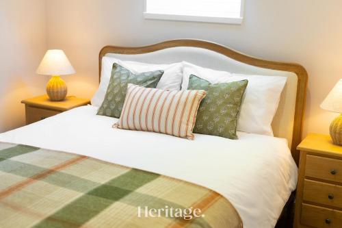 a bedroom with a white bed with pillows at The Byre, Countryside Home in Tough