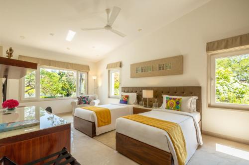 a hotel room with two beds and a desk at Helen's Garden , Bhopal in Bhopal