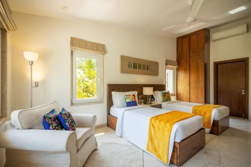 a hotel room with two beds and a couch at Helen's Garden , Bhopal in Bhopal