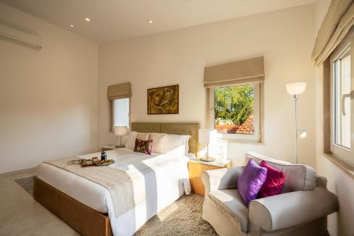 a bedroom with a large bed and a chair at Helen's Garden , Bhopal in Bhopal