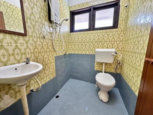 a bathroom with a toilet and a sink at Homestay The Wooden Port Dickson in Port Dickson