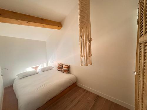 Cette chambre comprend un lit avec des draps blancs et du parquet. dans l'établissement CB Cannes - JUNGLE, à Cannes