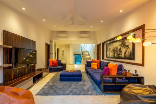 a living room with a blue couch and a flat screen tv at Helen's Garden , Bhopal in Bhopal