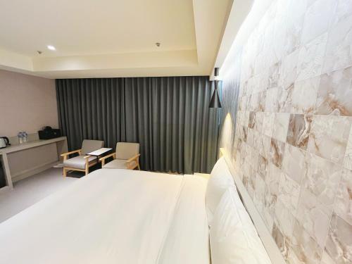 a hotel room with a bed and a table and chairs at 新仕飯店-New City Hotel in Taipei