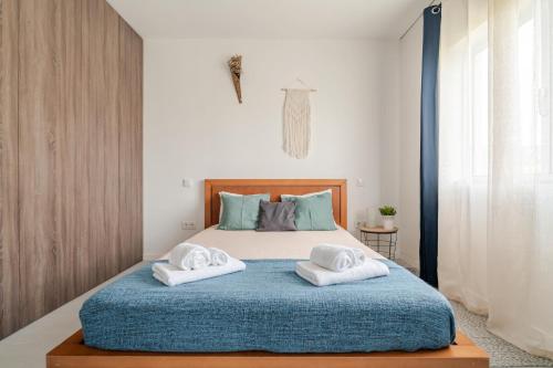 a bedroom with a bed with towels on it at Casa dos Pirulitos in Apúlia
