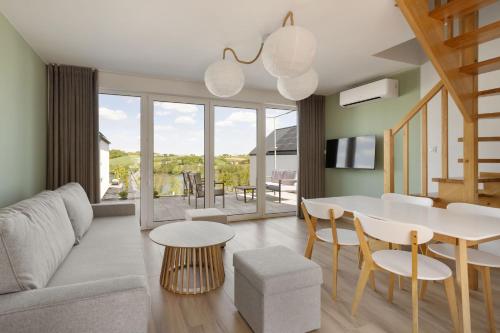 a living room with a couch and a table and chairs at Raduńskie Zacisze in Chmielno