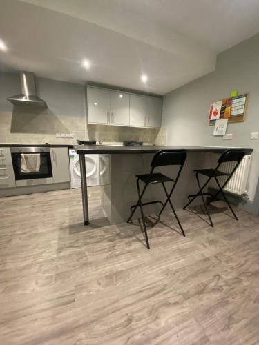 a kitchen with a desk and two chairs in a room at 15 on Hill Crescent, 6 en-suite bedrooms, Sleeps 12 in Skegby