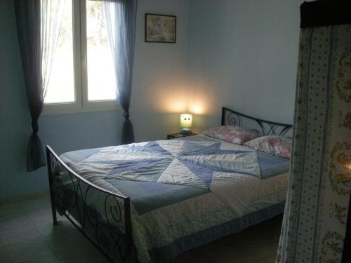 une chambre avec un lit avec une couette dessus dans l'établissement Appartement pour 4 personnes, à Roquefort-la-Bédoule