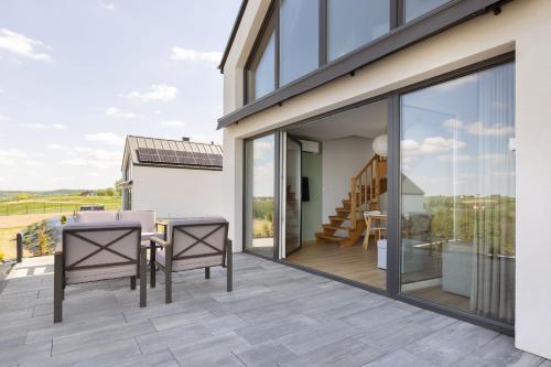 a patio with glass doors and a table and chairs at Raduńskie Zacisze in Chmielno