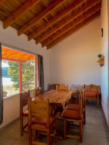 a dining room with a wooden table and chairs at Complejo Don Cirilo in Villa Pehuenia