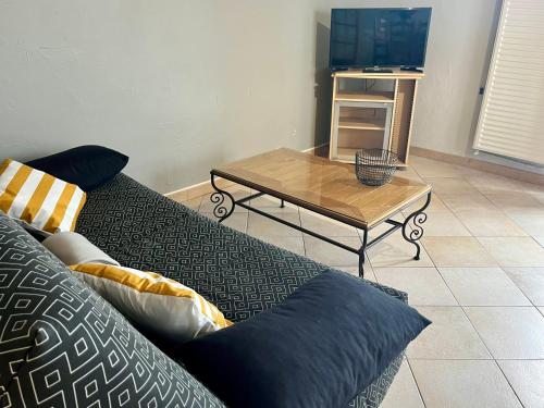 a living room with a couch and a coffee table at Gîtes de la Mouette Le Tourteau 5-6 pers in Ravenoville