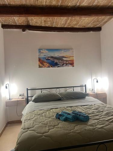 a bedroom with a bed with two blue shoes on it at Minorca Studios in Alghero