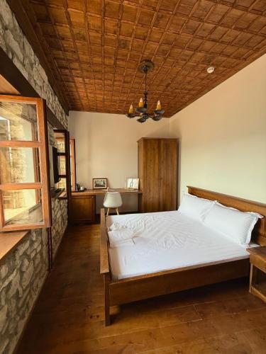 a bedroom with a large bed with a wooden ceiling at Villa Merkaj, Berat Castle in Berat