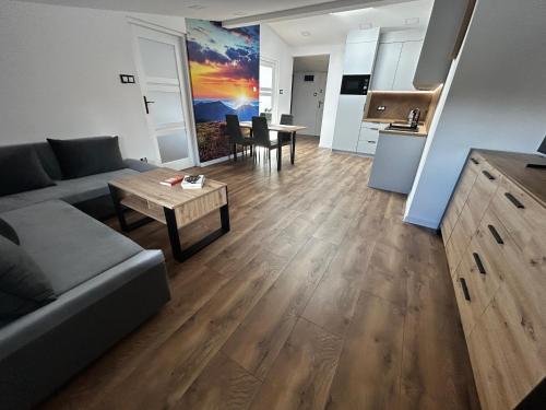 a living room with a couch and a table at Loft Apartments Bielawa "Wschód Słońca" Polskie Como Góry Sowie in Bielawa