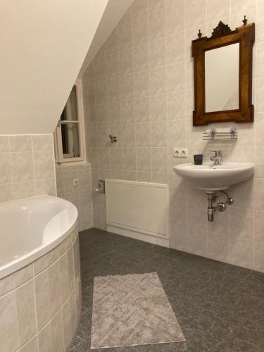 a bathroom with a sink and a bath tub and a mirror at Katharina Haus, Wiel in Wiel