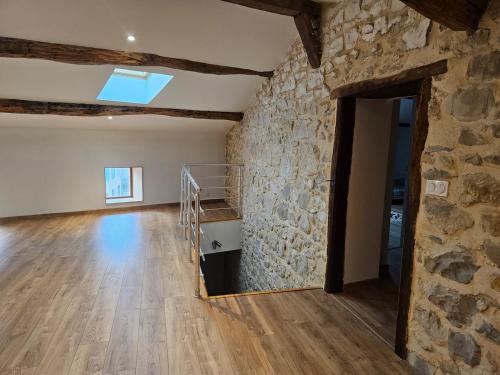 Cette grande chambre est dotée d'un mur en pierre et d'un escalier. dans l'établissement L'Escapade Marsannaise - Grande maison de village, à Marsanne
