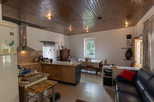 une cuisine et un salon avec un canapé dans l'établissement Maison de village - l'Externat, à Laurac-en-Vivarais
