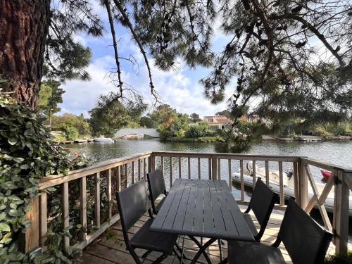 une table et des chaises sur une terrasse à côté d'une rivière dans l'établissement San Ciprianu, à Porto-Vecchio