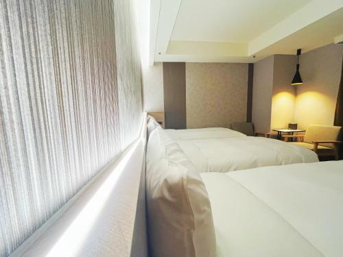 a hotel room with two beds and a window at 新仕飯店-New City Hotel in Taipei