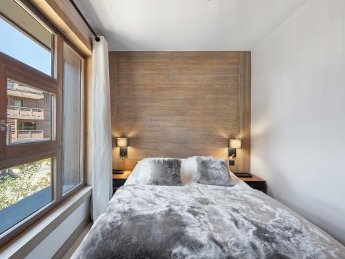 une chambre avec un grand lit et une fenêtre dans l'établissement Appartement avec Espace Bien-Être à Megève, Piscine, Salle de Sport et Parking Électrique - FR-1-569-34, à Megève