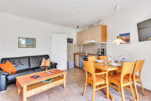 a kitchen and a living room with a table and chairs at Appartment Sünnschien in Kronsgaard