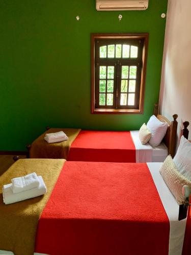 two beds in a green room with a window at Casa Augusta - QUINTA in Penafiel