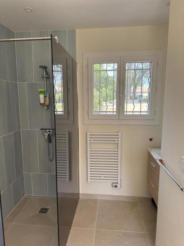 une salle de bain avec une cabine de douche et deux fenêtres dans l'établissement Villa 