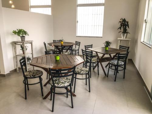 a group of wooden tables and chairs in a room at Pousada dos Ventos Itanhaém in Itanhaém