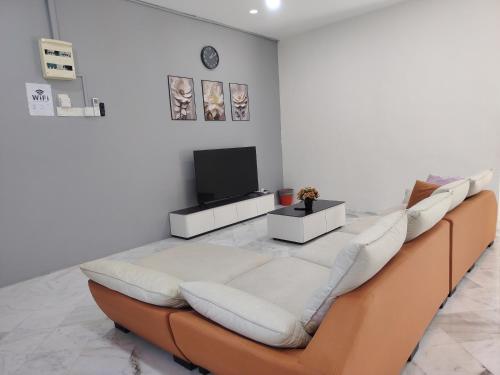 Una sala de estar con un sofá y un televisor de pantalla plana. en Pearl Villa 5 Bedroom Unit 13, en Port Dickson