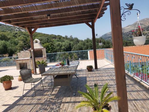 a patio with a table and chairs on a deck at LEMON TREE GARDEN near Mirtos beach in Bekatoráta
