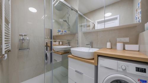a bathroom with a washing machine and a sink at Sand Dunes, Sun & Snow in Dziwnów