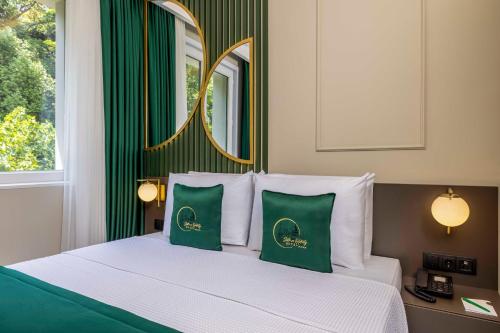 a bedroom with a bed with green and white pillows at Sistina Old City Hotel in Istanbul