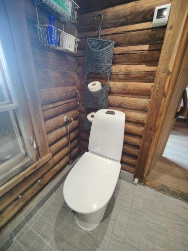 a toilet in a bathroom with wooden walls at Cabin Pikku Saana in Kilpisjärvi