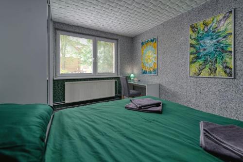 a bedroom with a green bed and a window at Magic experience 2 bedroom 70 m2 apartment in Tatranska Lomnica by Gavrieli in Vysoké Tatry