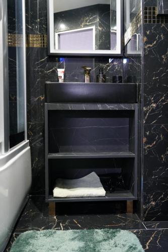 a black bathroom with a sink and a mirror at Magic experience 2 bedroom 70 m2 apartment in Tatranska Lomnica by Gavrieli in Vysoké Tatry