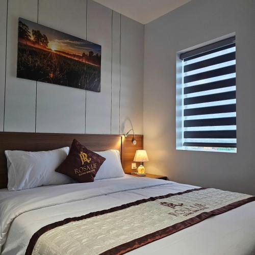 a bedroom with a large bed and a window at RosaLie Quảng Bình Hotel in Dong Hoi