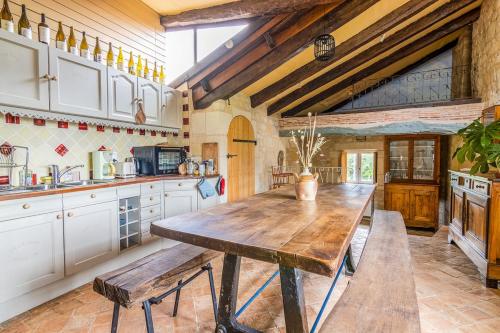 une grande cuisine avec une table en bois. dans l'établissement Gite Divin 8 personnes, à Forges